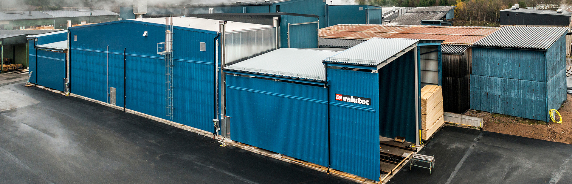 Kanaltork FB från Valutec i blå fasad, med öppning där virkespaket lastas in för torkning.