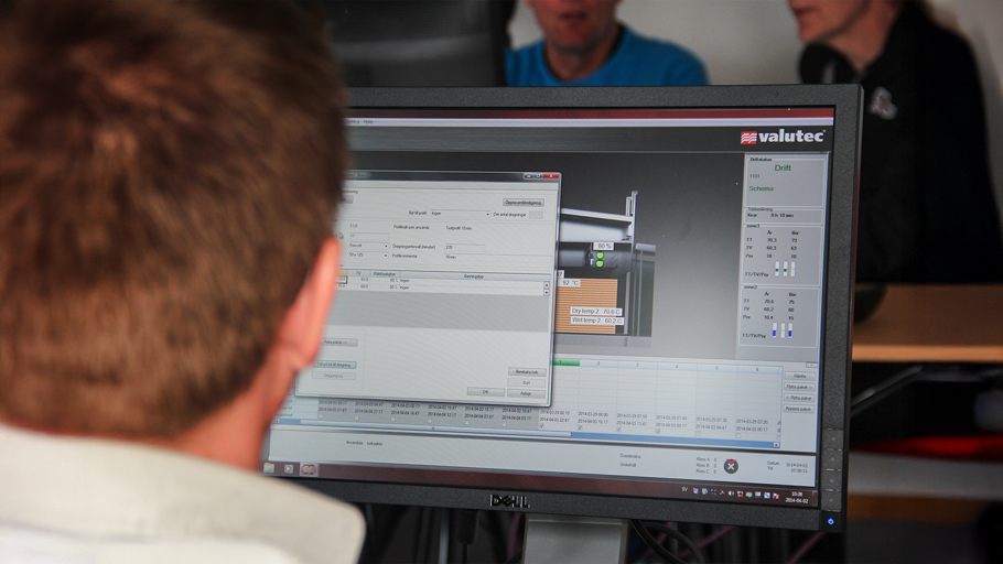 Operatör övervakar Valutecs styrsystem för virkestork via dator, med realtidsdata om temperatur och fuktnivåer.