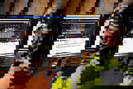 Man sedd bakifrån som tittar på data på en datorskärm.