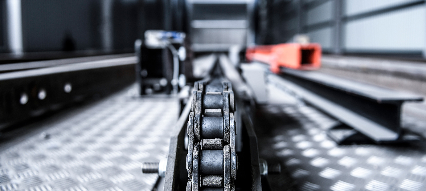 Närbild av industriell kedja och metallkomponenter i Valutecs virkestorkssystem.