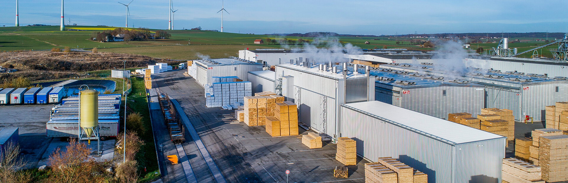 Kanaltork TC från Valutec, del av ett större sågverksområde med staplat virke och ånga från torkarna.