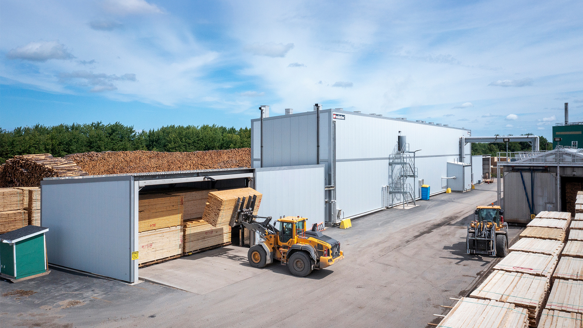 Valutec kanaltork med frontlastare som lastar in virkespaket.